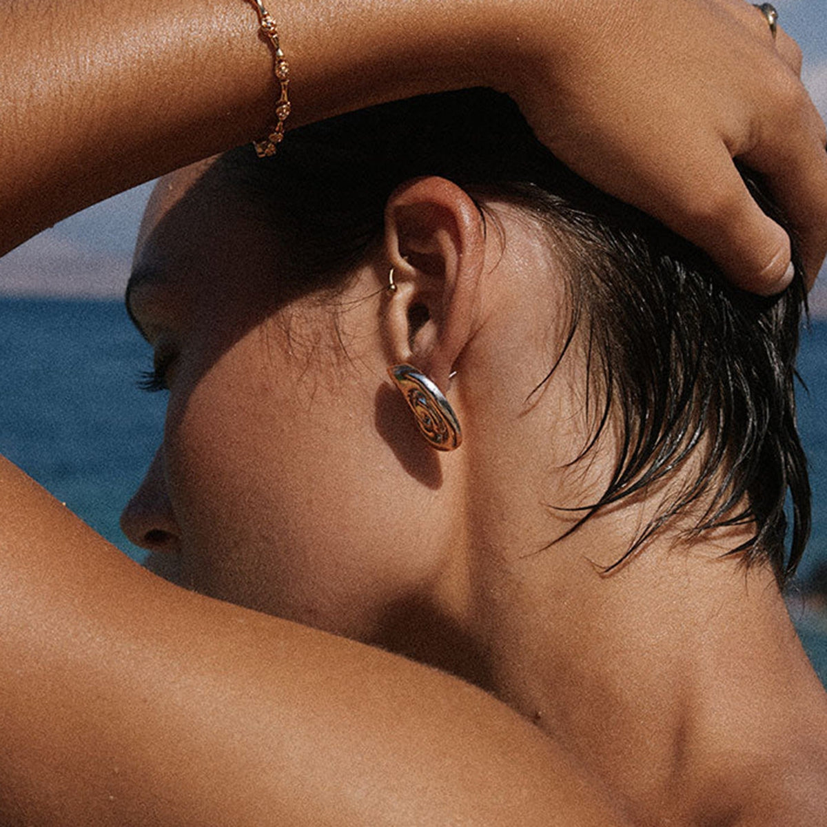18K gold conch-shaped earrings with gold and silver color matching design and ocean style